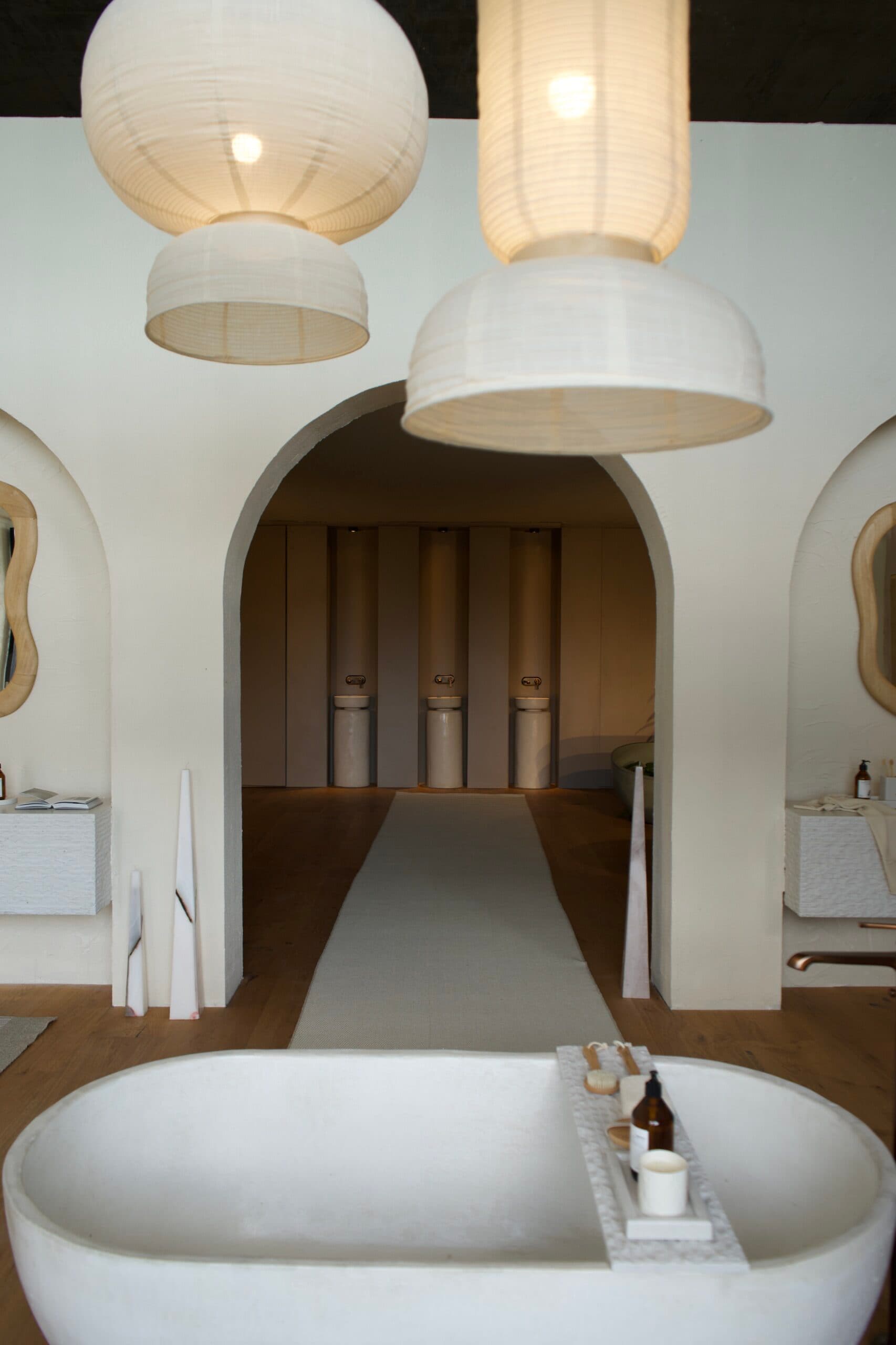 Baño con bañera exenta, arcos y lámparas de papel